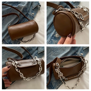 Detail view of brown cylindrical crossbody bag featuring a silver chain and FASHION & BMH text