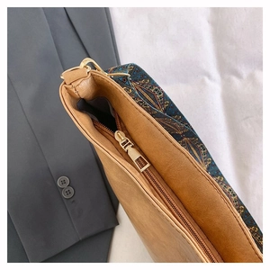 Detail of the golden zipper and ethnic print fabric on the brown leather tote bag