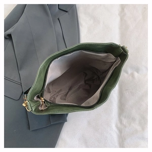 Detailed interior of the dark green tote bag featuring gray lining and zipper pocket