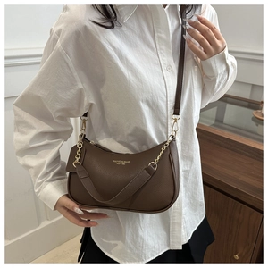Détail du sac croissant en cuir marron foncé avec chaîne dorée et bandoulière