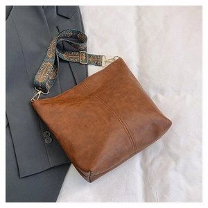 Detailed view of the brown leather tote bag with vintage texture and tribal strap