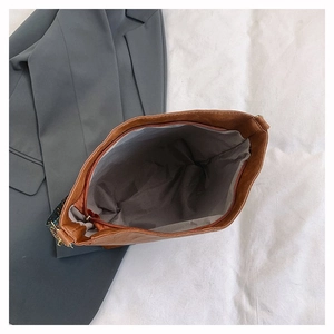 Top view of spacious brown leather tote bag interior with grey lining and smooth zipper