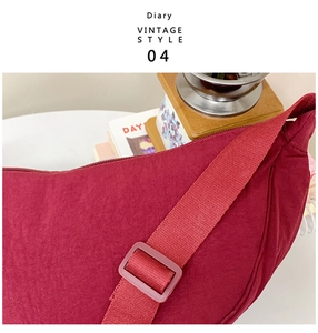 Detailed view of dark red dumpling bag strap with adjustable buckle in vintage style