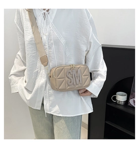 Detail van gewatteerde beige crossbodytas met 3D-logo en een brede stoffen schouderriem