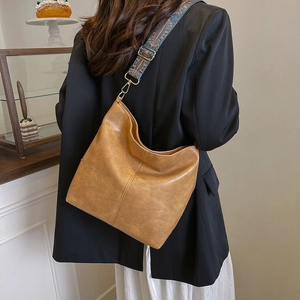 Detail of vintage brown hobo bag featuring stylish bohemian patterned wide shoulder strap
