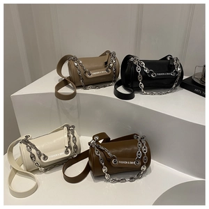Detail of four cylinder crossbody bags in beige, black, white, and brown with silver chains