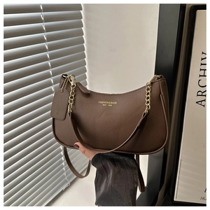 Détail du sac en cuir marron à motif litchi avec chaîne dorée et logo élégant