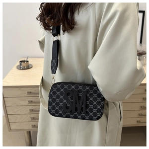 Detail view of the monogram crossbody camera bag featuring a bold SM letter logo and wide strap