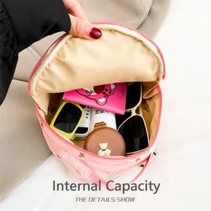 Detail showing the internal storage capacity of the pink round bag with travel essentials