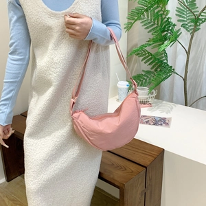 Pink minimalist half-moon crossbody bag with adjustable strap and nylon pleated texture