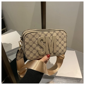 Detail of vintage patterned crossbody camera bag with 3D SM logo and wide fabric strap