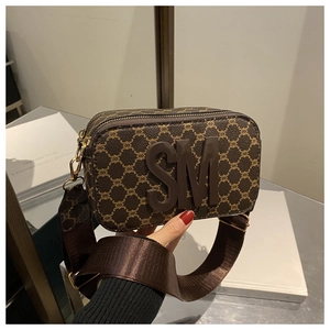 Close-up of vintage brown monogram camera bag with 3D SM logo and wide shoulder strap