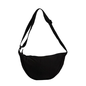 Minimalist black crescent crossbody bag with adjustable strap and smooth zipper closure