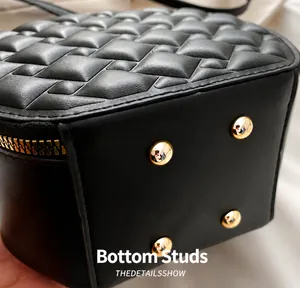 Detailansicht des schwarzen Stepptaschenbodens mit vier goldenen Metallfüßen