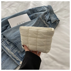 Detail of white quilted nylon makeup pouch with soft padded texture and square stitching