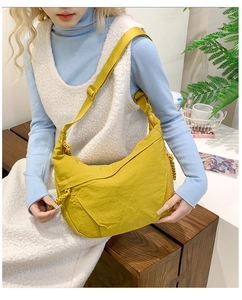 Detail of the bright yellow pleated nylon crescent bag with woven zipper pull detail