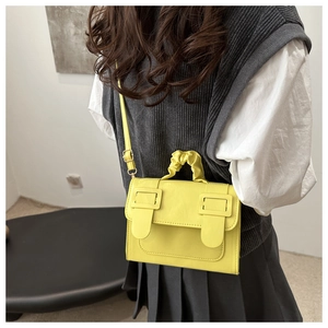 Détail du sac bandoulière jaune avec une poignée nuage froncée unique et design moderne