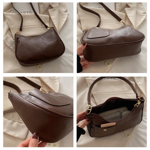 Detailed close-up of brown leather crescent bag showing stitching and metal hardware