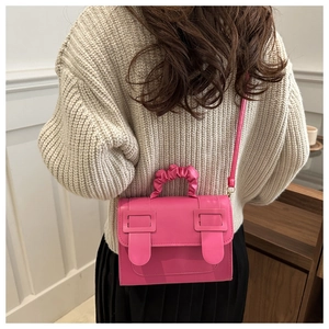 Sac bandoulière rose mat avec poignée plissée porté par un mannequin vue de l'arrière