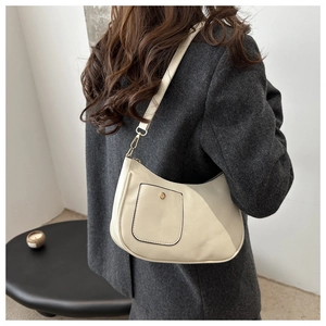 Detail of a beige leather crescent hobo bag with a retro gold buckle on gray wool coat