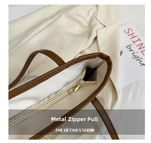 Detailed close-up of golden hardware zipper and brown trim on a woven tote bag
