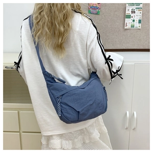Blue nylon crossbody crescent bag with textured fabric and matching zipper details