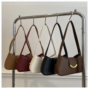 Detalle de bolsos de hombro en cinco colores con elegante cierre de media luna dorado