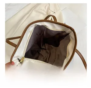 Detail view of large straw tote bag with brown fabric lining and golden metal zipper