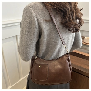 Detailed view of brown PU leather hobo bag with gold hardware and front pocket design