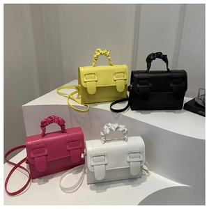 Détail de quatre petits sacs bandoulière carrés en jaune, noir, rose fuchsia et blanc