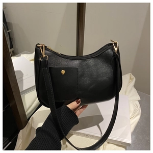 Close-up of black crescent shoulder bag with front pocket and gold metal buckle detail
