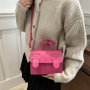 Sac à bandoulière rose fuchsia en cuir PU avec poignée plissée porté par un modèle