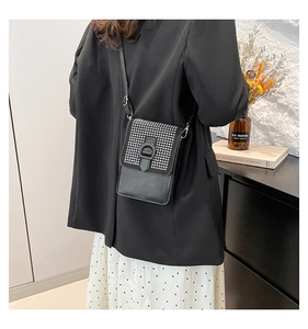 Détail d'un mini sac bandoulière noir orné de strass brillants avec rabat à boucle chic