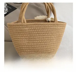 Détail du sac cabas en paille tissée avec bordure en dentelle blanche et anses