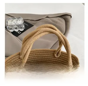 Détail du sac cabas tressé avec poignées en corde épaisse et nœud en dentelle blanche