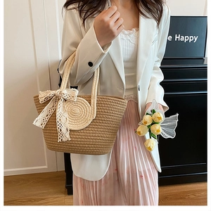 Detail der gewebten Stroh-Tragetasche mit Spitzenschleife und Modell im Freizeit-Look
