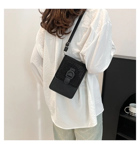 Détail du petit sac bandoulière noir avec rabat en strass et large boucle décorative