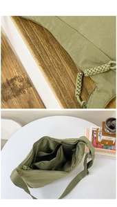 Detailed macro view of olive green nylon bag showing zipper texture and spacious interior