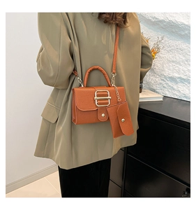 Detail of brown litchi pattern leather bag with golden buckle and detachable mini pouch