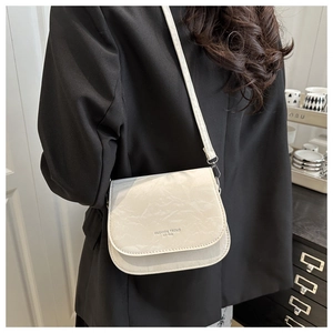 Détail du sac bandoulière crème avec texture pierre et lettrage Fashion Trend 1996