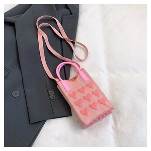 Detalle del mini bolso de punto rosa con diseño de corazón 3D y textura de las asas