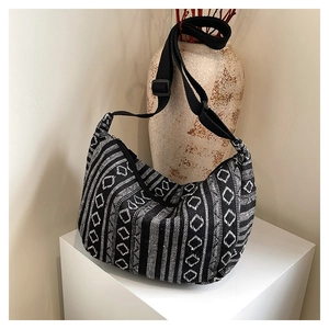 Détail macro du motif ethnique tissé et de la bandoulière réglable sur sac en toile