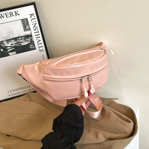 Pink glossy patent leather crossbody chest bag with adjustable strap and dual zippers