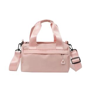 Bolso cilíndrico rosa con asas superiores y correa ajustable sobre fondo blanco para mujer chic