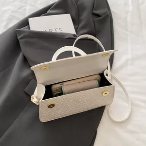 Detail view of woven white crossbody bag interior showing magnetic buckles and storage capacity