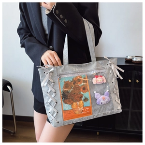 Detail of grey PU tote bag with ribbon lace-up sides and transparent display window