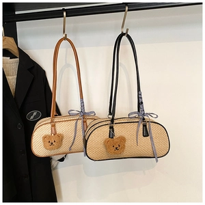 Details van geweven stro baguette tassen met lederen riemen en pluchen beer hanger