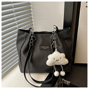 Nahaufnahme der schwarzen Twill-Tasche mit Silberkette und Plüsch-Wolkenanhänger