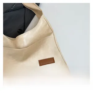 Detailed view of soft beige synthetic leather fabric texture with a brown patch on the bag