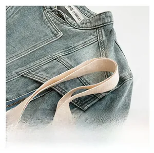 Détail de la bandoulière tressée crème sur une robe d'été en jean bleu clair